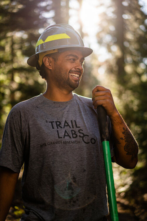 Gateway trail worker smiling with a shovel in the forest